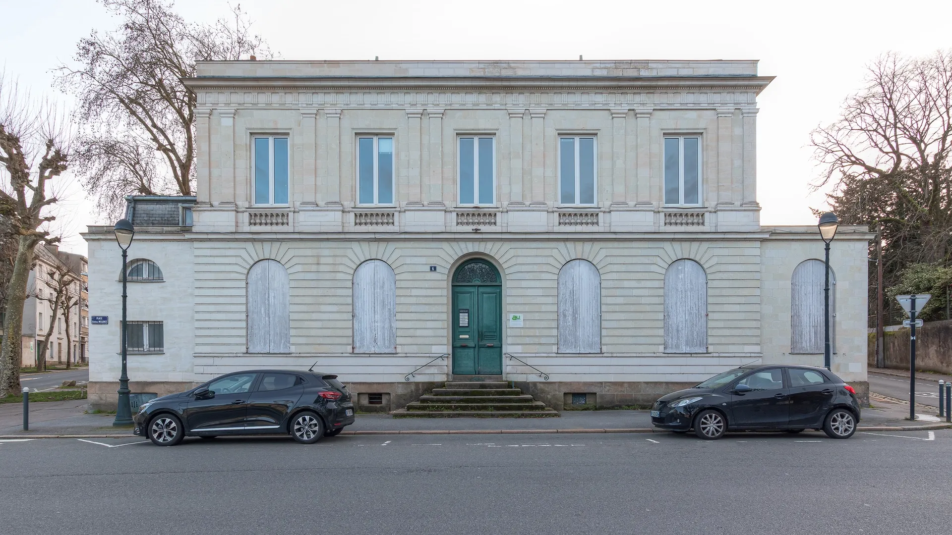 Façade d'un hôtel particulier en pierre de taille au 6 Place Général Mellinet à Nantes, abritant des professionnels de santé. Porte d'entrée verte et architecture néoclassique.