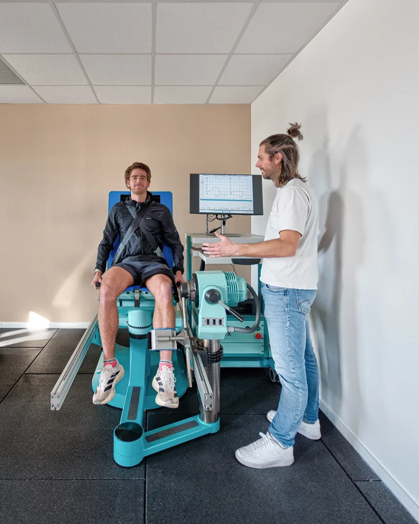Photographie d'un kinésithérapeute du sport expliquant les résultats d'un test de force sur un dynamomètre isocinétique à un patient sportif au cabinet Hélios Santé à Nantes
