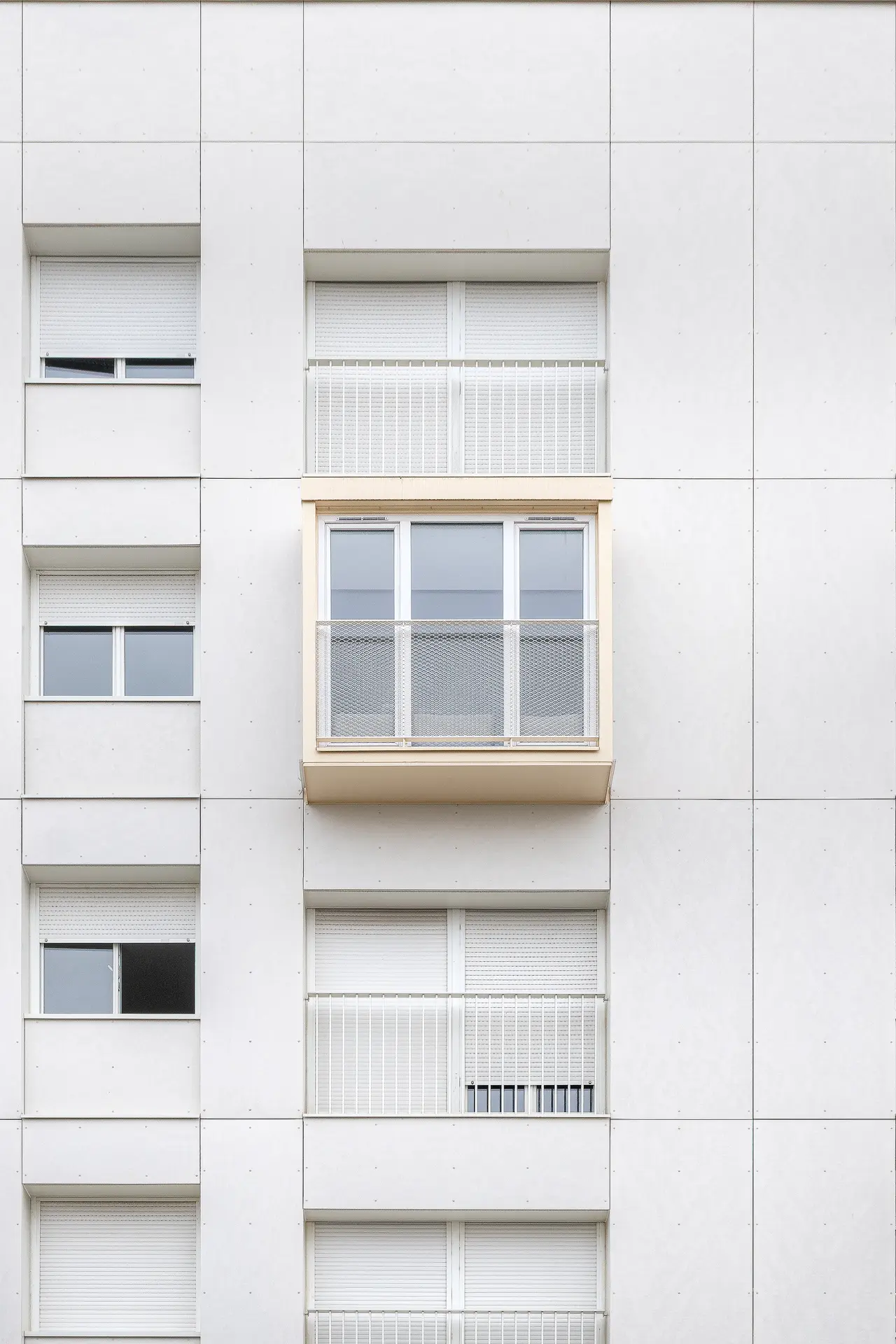 Gros plan graphique de la façade blanche isolée (BBC) avec un bow-window central en saillie, reportage photo architecture à Nantes.