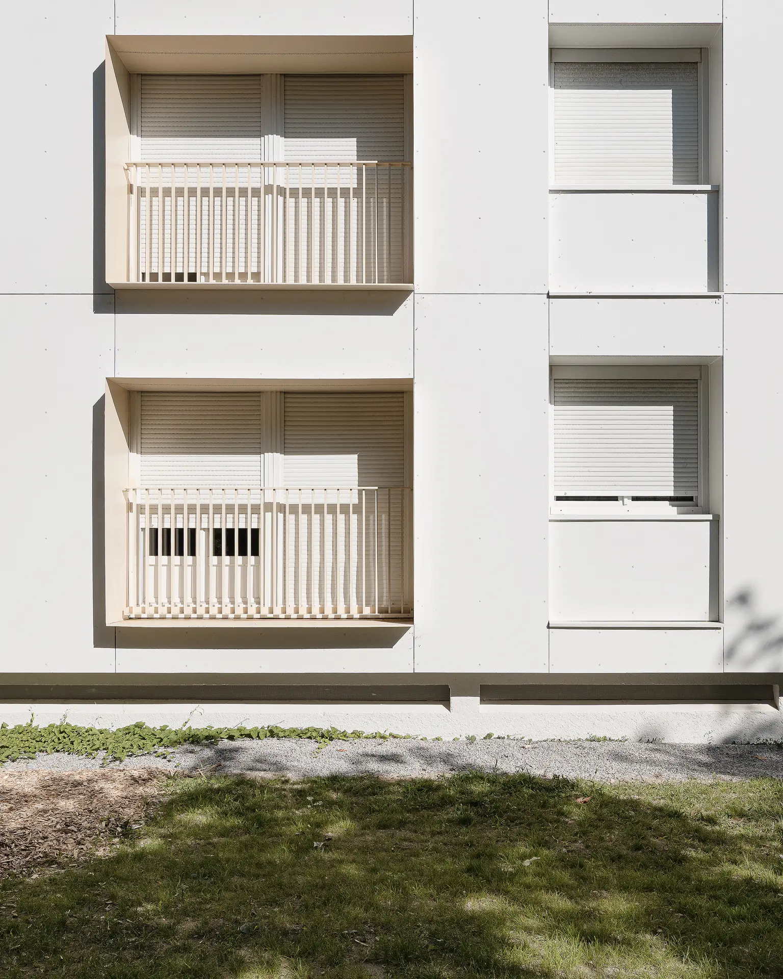 eux d'ombres et de lumières sur le détail des cadres de fenêtres en saillie et volets roulants d'un immeuble rénové aux normes thermiques.